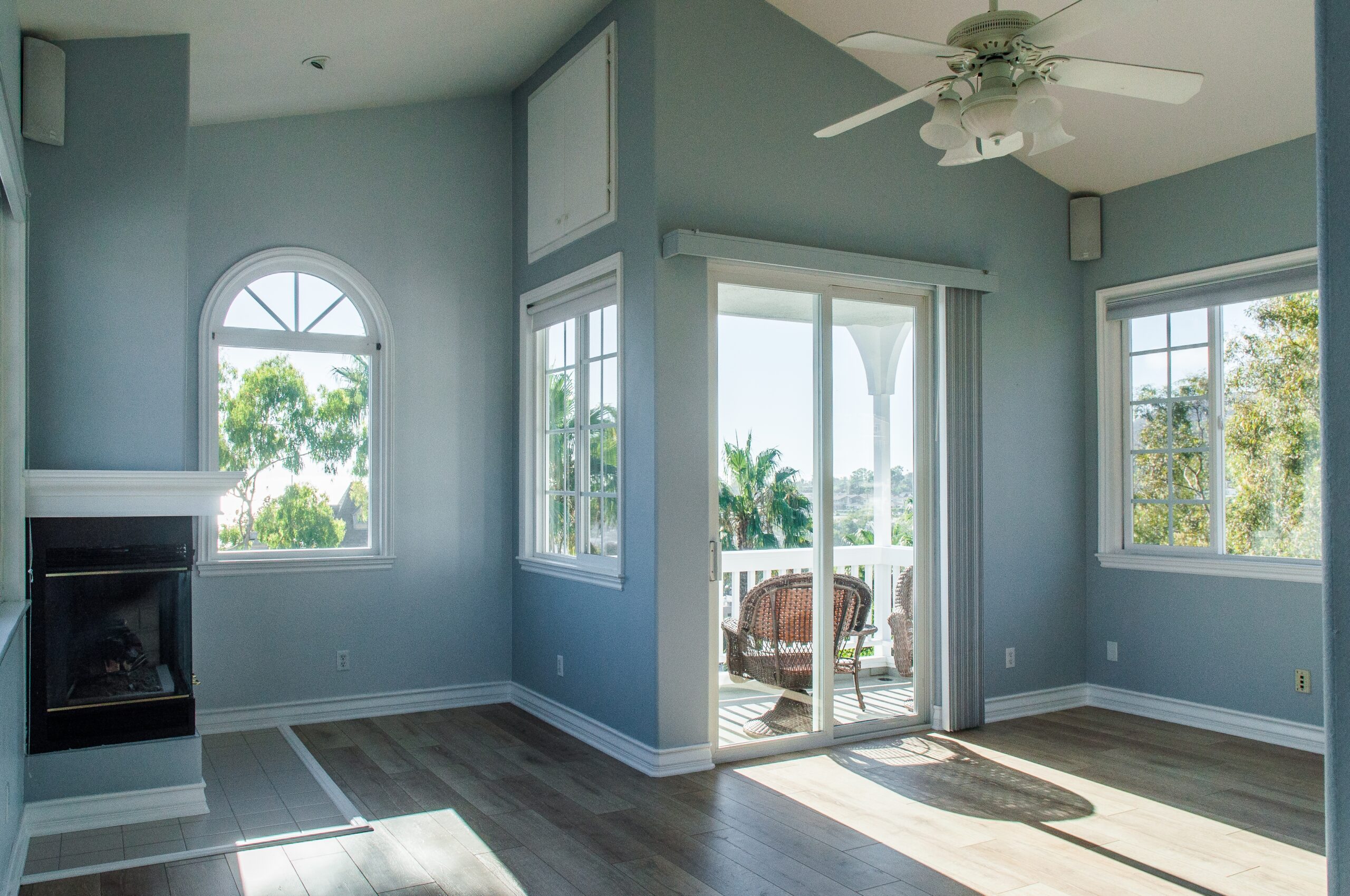 A trendy modern interior of a living room with blue walls and white windows
